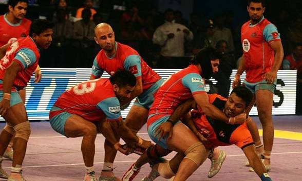 Jaipur Pink Panthers players attempt to tag the U Mumba team raider (R, in orange) during the final match between U Mumba and Jaipur Pink Panthers in the Pro Kabaddi League in Mumbai on August 31, 2014. &mdash; AFP/File